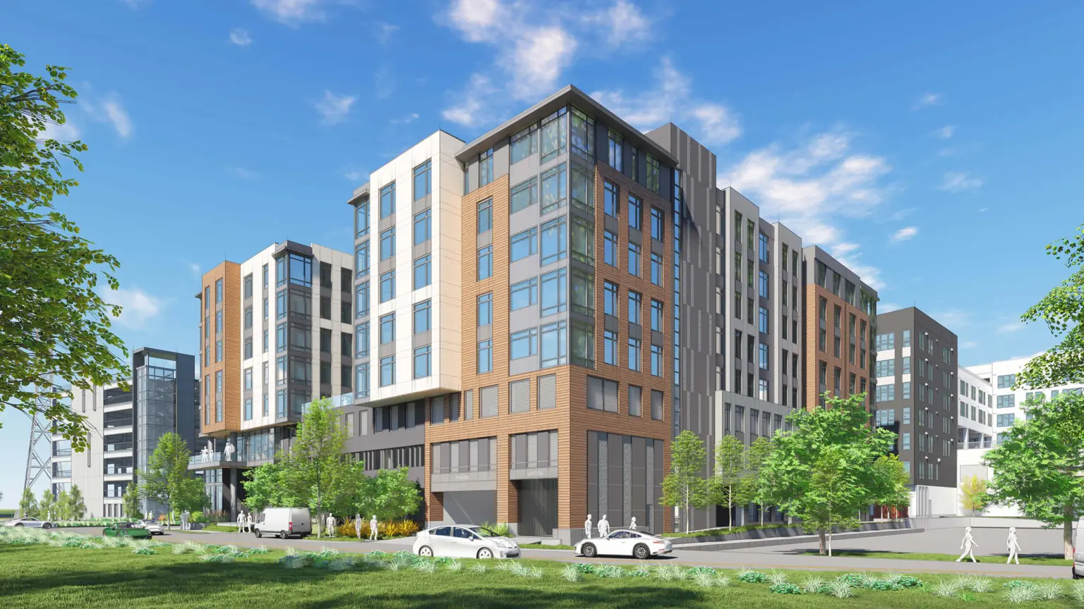 A rendering of the apartment building proposed at 104 Constitution Drive: a mid-rise building with wood-toned and white panels and a glass corner, among other new buildings, with a street and a lawn in front.