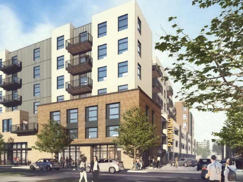 Rendering from Alliant Communities’ proposal: an apartment building on a downtown street, with a public parking garage beside it.